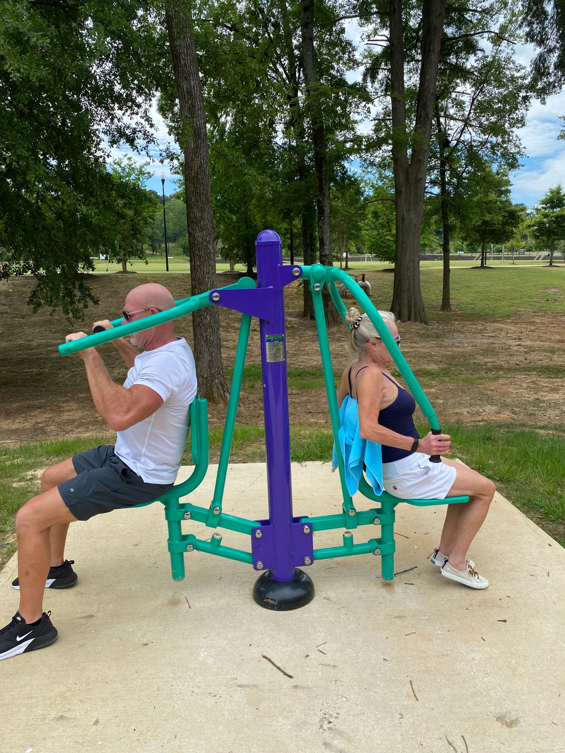 Man and Woman Using Chest Press-Lat Pull Equipment