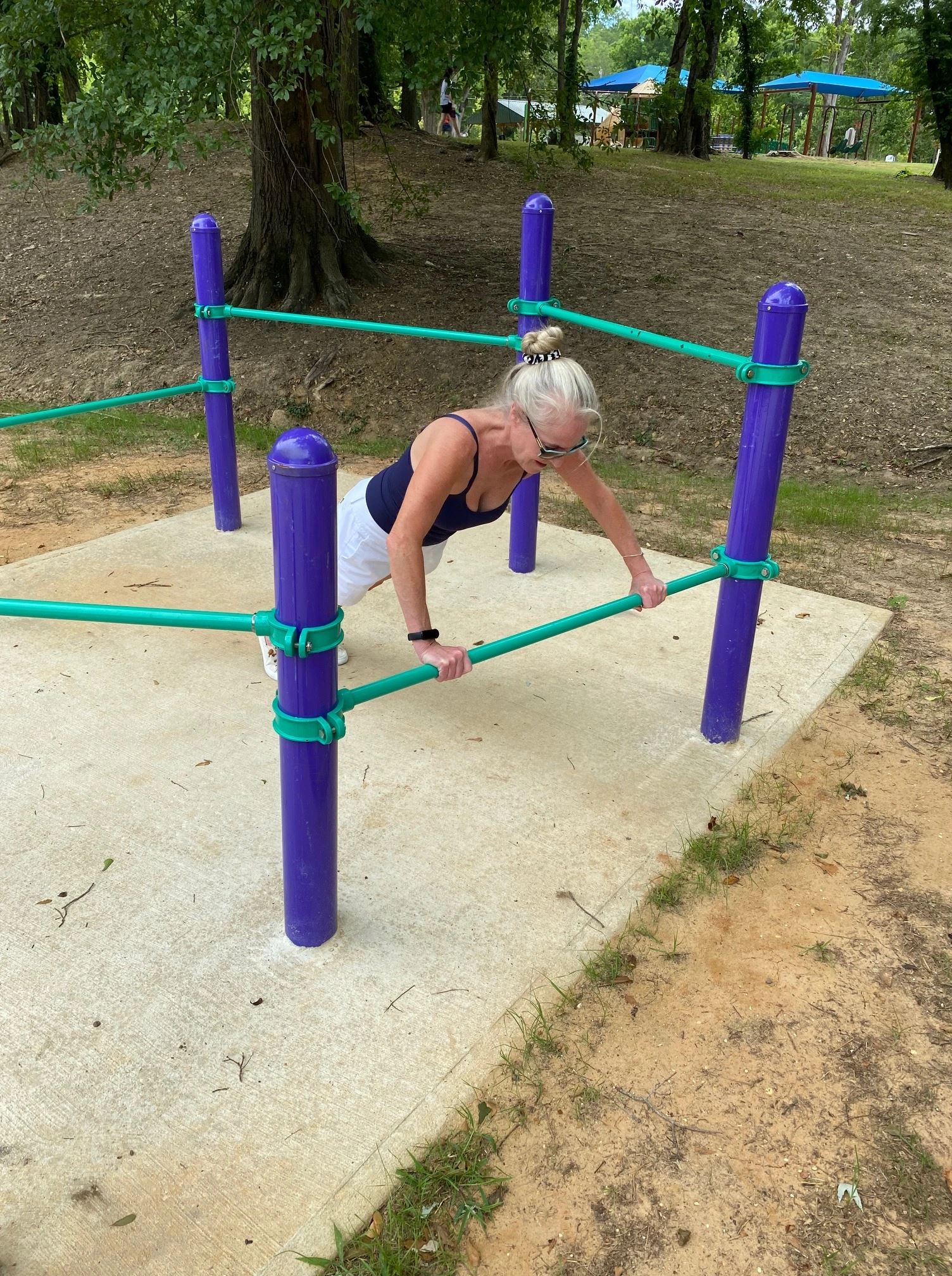 Woman Doing Push-ups on the Strength and Stretch Bar